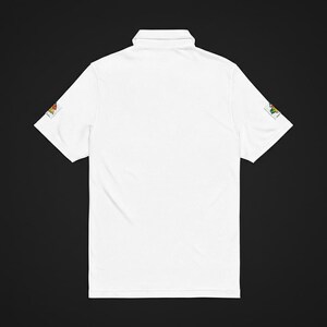 The back of the white polo shirt showing plain fabric with patches visible on both sleeve hems against a dark background.