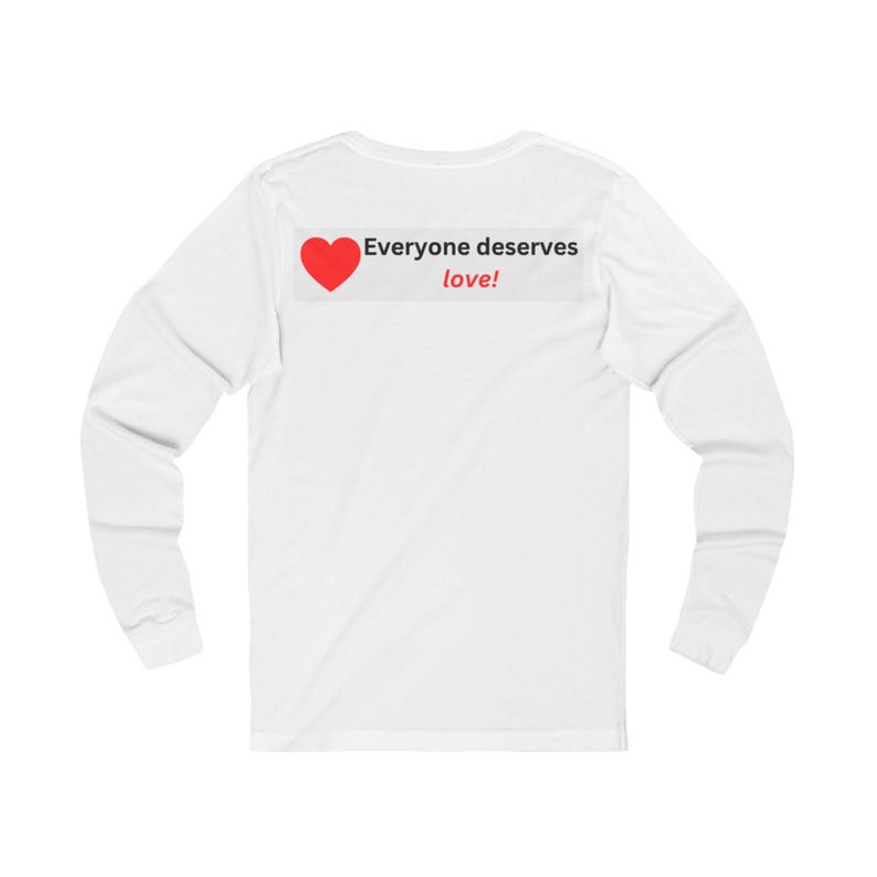 Back view of a white long-sleeve t-shirt with a rectangular graphic near the back collar displaying a red heart and the text Everyone deserves love!.
