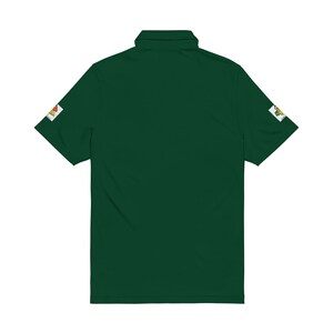 The back of a dark green polo shirt with a plain solid back and visible patches on both sleeves against a white background.
