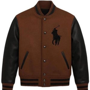 Op de afbeelding: Bruine varsity jas met zwarte leren mouwen. Voorzien van een zwart geborduurd logo op de borst en zwart-bruine gestreepte afwerking op de kraag, manchetten en zoom. De jas heeft een knoopsluiting en twee voorzakken.