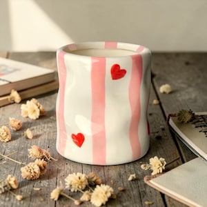 Op de afbeelding: Een set van drie keramische mokken met een gespikkelde, matte afwerking. De mokken zijn in tinten crème, lichtgrijs en donkergrijs. Elke mok heeft een eenvoudig, minimalistisch ontwerp en een afgeronde handgreep.