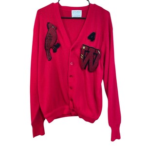 May include: A bright red cardigan sweater with a V-neck and button closure. The sweater features a cardinal bird patch on the left chest and a large "W" patch with a number "4" on the right chest. The label reads "JEFFLINKS".