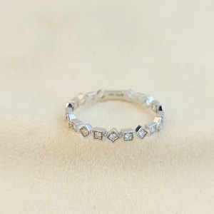 10K solid gold geometric eternity band ring with natural diamonds set in square zigzag pattern, elegant minimal diamond gold ring photographed on soft neutral background
