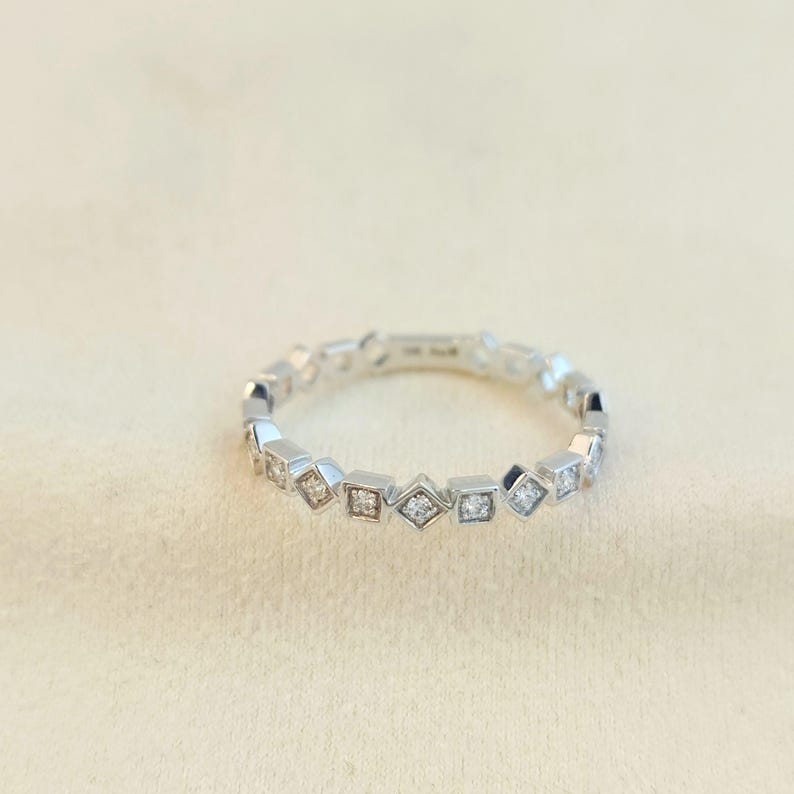 10K solid gold geometric eternity band ring with natural diamonds set in square zigzag pattern, elegant minimal diamond gold ring photographed on soft neutral background