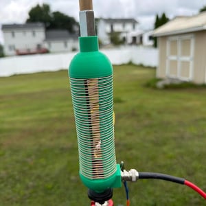 May include: A green 3D-printed cylindrical coil antenna component featuring a tightly wound copper wire spiral. The device is mounted on a red UTEBIT ball head adapter and includes a black coaxial cable with a silver connector attached to the side.