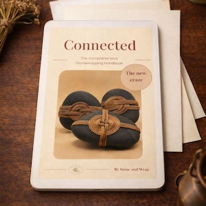Könnte beinhalten: Ein digitales Handbuch mit dem Titel "Connected" und dem Untertitel "The Comprehensive Stonewrapping Handbook". Das Cover zeigt drei dunkle Steine, die mit braunem Bindfaden umwickelt sind. Der Text auf dem Cover lautet "The new craze" und "Instant Download PDF".