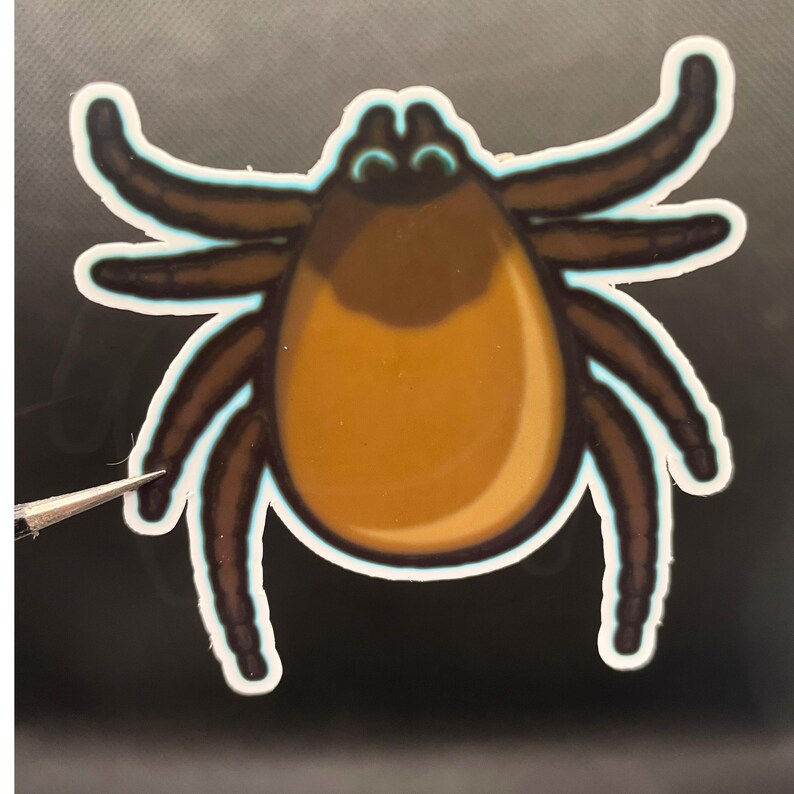 May include: A sticker featuring a stylized illustration of a tick with a large, rounded, golden-brown abdomen, a dark brown head, and eight segmented dark brown legs, all outlined with a thin, glowing light blue border.