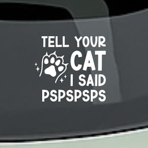 以下が含まれることがあります： 「TELL YOUR CAT I SAID PSPSPSPSPS」のテキストが入った白いデカール。デザインには足跡とキラキラが含まれています。デカールは、車の窓など、同様の表面に使用される可能性があります。