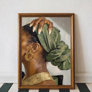 Peut inclure: Portrait encadré d'une personne avec un foulard vert et des créoles dorées. Une main aux longs ongles clairs repose sur le foulard. Le portrait est dans un cadre en bois marron.
