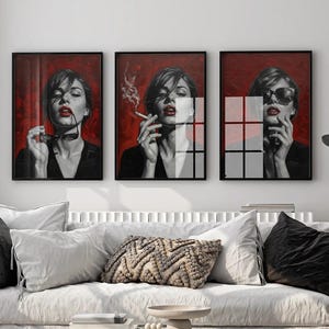 Puede incluir: Tres impresiones artísticas enmarcadas que representan a una mujer con lápiz labial rojo y gafas de sol sobre un fondo rojo. La mujer se representa en diferentes poses, sosteniendo gafas de sol, fumando y usando gafas de sol.
