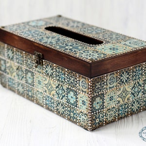 May include: A wooden tissue box cover with a decorative tile pattern in shades of blue, green, and gold. The box has a hinged lid and a slot for pulling out tissues.