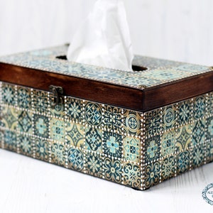 May include: A wooden tissue box cover with a decorative design of blue, green, and gold tiles. The box has a hinged lid and a brass latch.