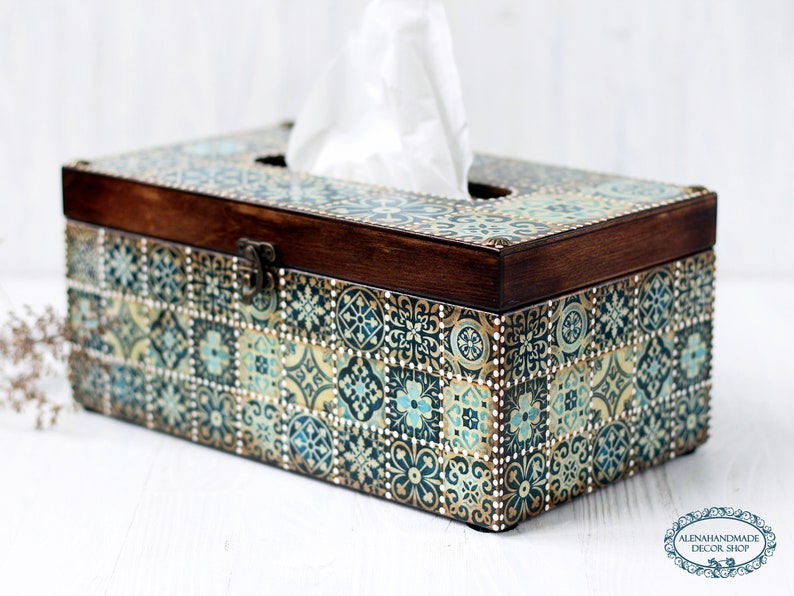 May include: A wooden tissue box cover with a decorative design of blue, green, and gold tiles. The box has a hinged lid and a brass latch.