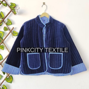 Könnte beinhalten: Marineblaue Steppjacke mit Stehkragen und zwei Vordertaschen. Die Jacke hat blau-weiß gestreifte Paspeln an Kragen, Taschen und Manschetten. Der Text "PINKCITY TEXTILE" ist auf der Jacke zu sehen.