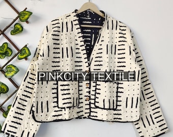 May include: Cream-coloured quilted jacket with a black geometric pattern and black trim. The jacket has a V-neck, two front pockets, and gold-coloured buttons. The text "PINKCITY TEXTILE" is visible.