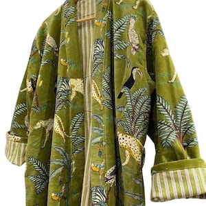 May include: Green velvet robe with a jungle print featuring leopards, zebras, toucans, and palm trees. The robe has a striped lining and cuffs. The robe is hanging on a wooden hanger.