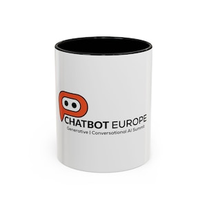 May include: White ceramic mug with a black interior and a logo that says "CHATBOT EUROPE" in black text. The logo is an orange and white speech bubble with a stylized eye. The text "Generative | Conversational AI Summit" is below the main text.