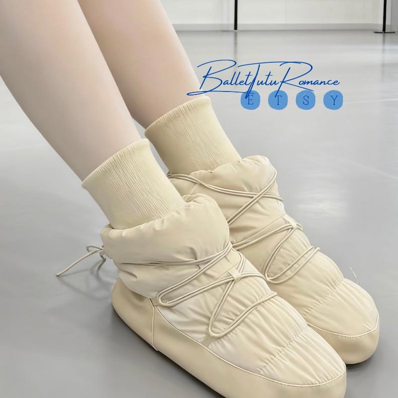 May include: Cream-colored quilted snow boots with a lace-up design. The boots have a puffy, padded appearance and are paired with cream-colored socks. The image includes the text "Ballet Tutu Romance" in a script font.