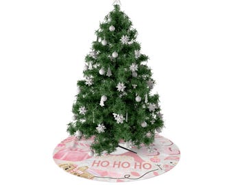 Könnte beinhalten: Ein geschmückter Weihnachtsbaum mit weißen Ornamenten und einem Sternaufsatz steht auf einem rosa Baumrock. Der Baumrock zeigt ein Muster mit Lebkuchenmännern, Zuckerstangen und dem Text "HO HO HO".