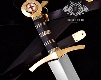 May include: A medieval sword with a gold hilt and a black handle, featuring gold accents. The sword has a silver blade and is accompanied by a black leather belt. The handle has a cross design. The text "FORGED GIFTS TREASURES" is visible.
