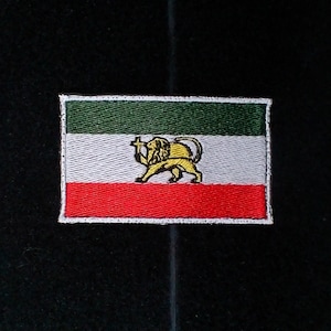 Puede incluir: Parche bordado con el diseño de la bandera histórica iraní. El parche rectangular tiene franjas horizontales verdes, blancas y rojas. Un león amarillo con una espada está centrado en la franja blanca. El parche tiene un borde blanco.