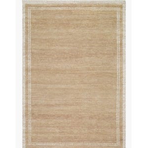 May include: Rectangular beige rug with a white dotted border. The rug has a simple, neutral design, suitable for various interior styles. The texture appears to be woven, adding visual interest. The rug's color is a warm, inviting tone.