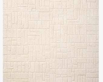 Alfombra moderna de lana anudada a mano, con textura geométrica en crema neutra, para interiores contemporáneos.