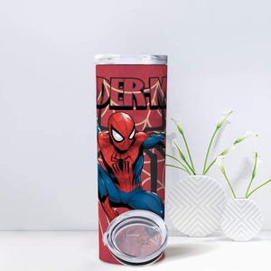 Op de afbeelding: Een rood-zwarte Spider-Man-beker met een zilveren deksel. De beker heeft een afbeelding van Spider-Man in zijn klassieke rood-blauwe pak, met het woord "Spider-Man" in grote letters.