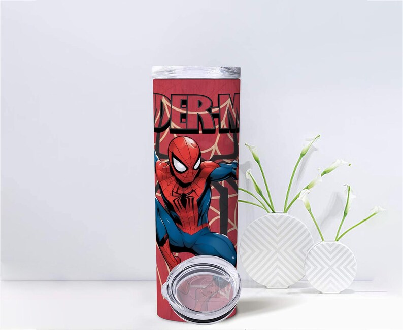 Op de afbeelding: Een rood-zwarte Spider-Man-beker met een zilveren deksel. De beker heeft een afbeelding van Spider-Man in zijn klassieke rood-blauwe pak, met het woord "Spider-Man" in grote letters.