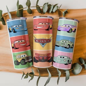 May include: Three stainless steel tumblers featuring colorful illustrations of characters from the animated movie "Cars." Each tumbler showcases different cars against a backdrop of vibrant colors, with the "Cars" logo prominently displayed on one.