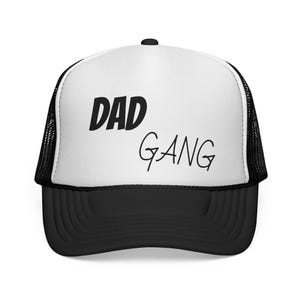 Könnte beinhalten: Schwarz-weiße Trucker-Cap mit dem Aufdruck "DAD GANG". Die Kappe hat eine weiße Frontplatte mit dem Text in Schwarz, einen schwarzen Schirm und eine schwarze Mesh-Rückseite.