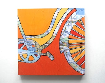 May include: Abstract art painting on canvas with a map of Los Angeles, California. The map is painted in shades of orange, yellow, and red. The painting is framed in a black frame.
