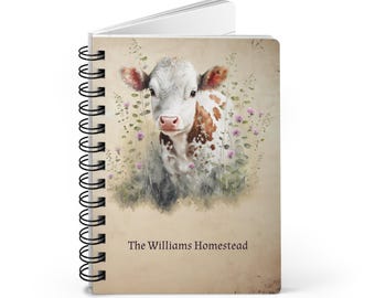 May include: A spiral-bound notebook featuring a watercolor illustration of a calf with white and brown markings, surrounded by pink flowers. The text "The Williams Homestead" is printed at the bottom of the cover.