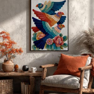 May include: A framed artwork featuring three stylized birds in flight. The birds have vibrant blue, red, orange, and teal wings, with matching beaks and eyes. The artwork is set against a textured white background, with colorful flowers at the bottom.