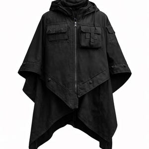 Op de afbeelding: Zwarte poncho met capuchon en meerdere voorzakken en een ritssluiting over de hele lengte. De poncho heeft een unieke, asymmetrische zoom en is gemaakt van een duurzame, donkere stof. Het ontwerp omvat een capuchon en knoopdetails.