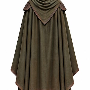 May include: An olive green hooded cloak featuring a structured hood, draped fabric panels, and brown leather-like trim along the edges and shoulder sections. The garment hangs in vertical folds and is paired with brown lace-up boots at the base.