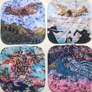 May include: Four square batik potholders with unique designs. One features an eagle over a landscape, another an eagle over mountains, a third an abstract design, and the last a peacock. Each has a loop for hanging.