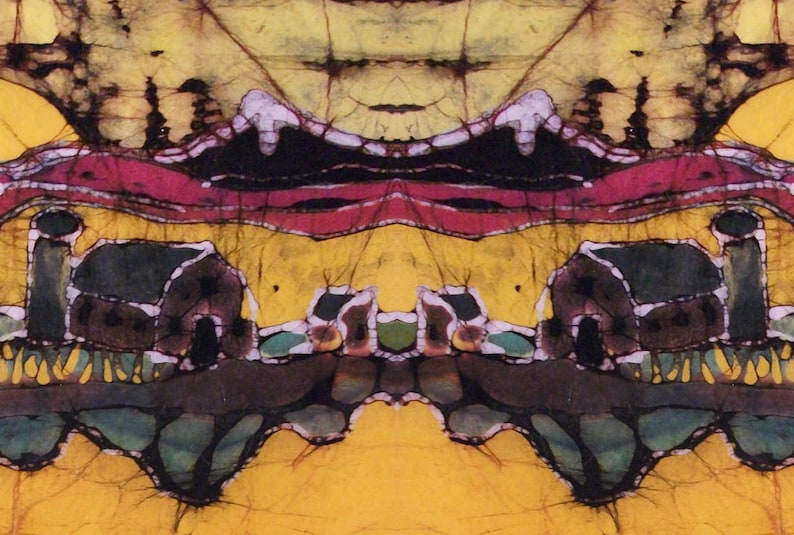 May include: Abstract batik art with a symmetrical design. The artwork features a vibrant colour palette of yellow, red, black, and green. The composition includes stylised landscape elements, possibly depicting buildings and natural forms.