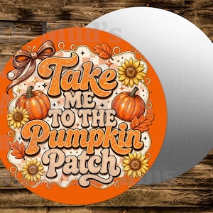 May include: A circular sign featuring the text Take Me To The Pumpkin Patch in orange and cream lettering. The design includes two orange pumpkins, yellow sunflowers, autumn leaves, and a brown ribbon bow against a checkered background.