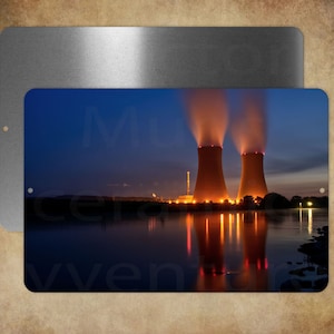 May include: Metal sign featuring a nighttime landscape with a power plant. Two large cooling towers emit steam under a dark blue sky. The scene is reflected in the water below, with the text "Musa Ceravven" partially visible.