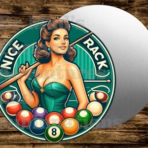May include: Round metal sign with a retro illustration of a woman holding a pool cue. The sign features the text "NICE RACK" and a collection of colorful billiard balls. The woman is wearing a green dress.