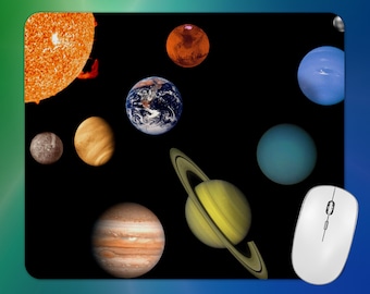 May include: A black mousepad featuring a colorful depiction of the solar system, including the sun, planets, and a moon. A white computer mouse is in the lower right corner. The planets are in various colors, including orange, blue, and yellow.