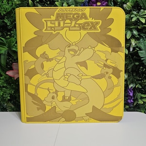 May include: Yellow card binder featuring a cartoon dragon design with the text "MEGA ドーレックス". The binder is made of a durable material and has a zip closure. The design is in shades of yellow and brown.