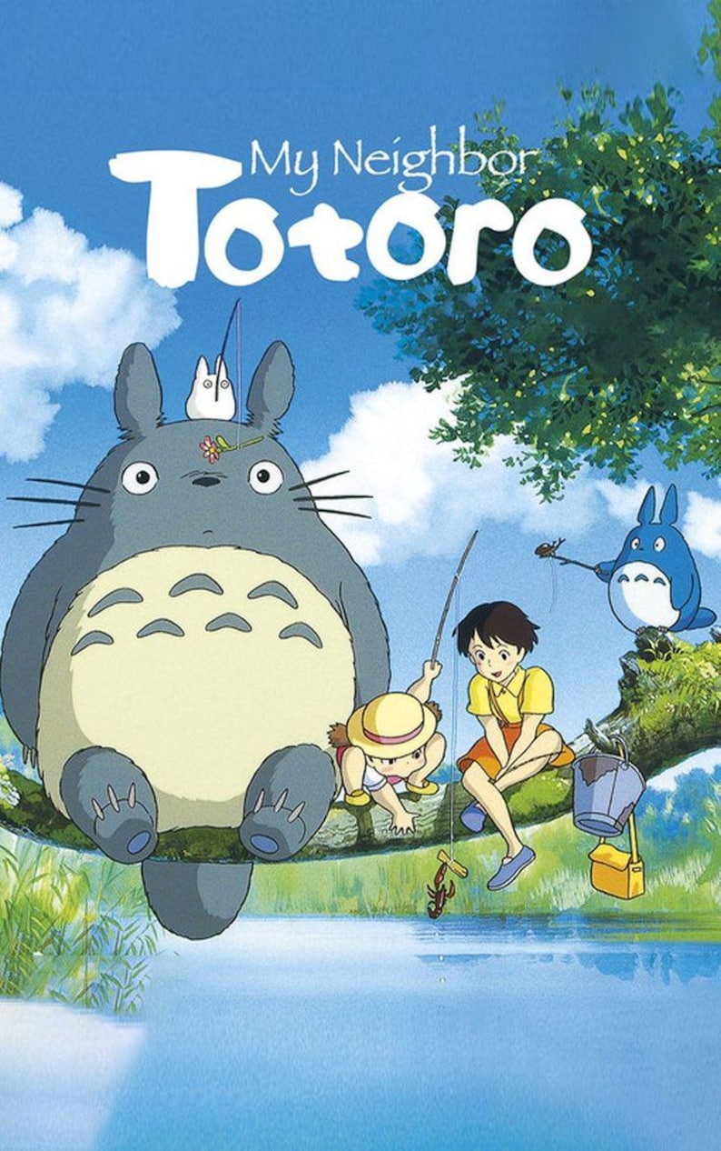 Pu&ograve; includere: Un poster con il testo My Neighbor Totoro che mostra una grande creatura grigia, una piccola creatura bianca, una creatura blu e due bambini seduti su un ramo di un albero sopra un fiume blu. I bambini tengono in mano canne da pesca.