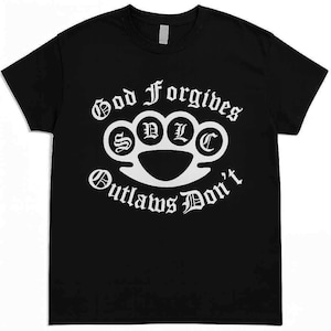 May include: Black t-shirt with a white graphic. The graphic features the words "God Forgives, Outlaws Don't" in a gothic font, along with a brass knuckle design with the letters "S D L C" inside the knuckles.