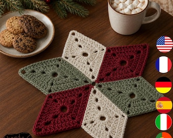 May include: A star-shaped crochet coaster or trivet featuring a geometric pattern of alternating cream, sage green, and deep red diamond-shaped motifs. The textile piece is crafted with a visible yarn texture and openwork centers in each section.