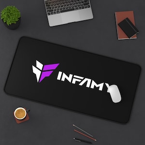 May include: Black rectangular mousepad featuring the word "INFAMY" in white, and a white and purple logo. A white computer mouse is on the right. A laptop, coffee cup, and small plant are also on the dark surface.