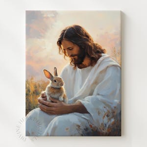 Puede incluir: Una impresión de arte digital representa a una persona con túnicas blancas sosteniendo un conejo marrón. La persona tiene cabello largo castaño y barba, con una luz suave y cálida en el fondo. La impresión se titula "Divine Heart Digitals".