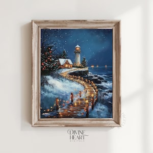 May include: A framed winter landscape painting featuring a lighthouse, a small house, and a wooden walkway illuminated by string lights. The scene is set against a dark blue night sky with falling snow, evoking a cozy, festive atmosphere. The artwork is signed "Divine Heart Digitals".