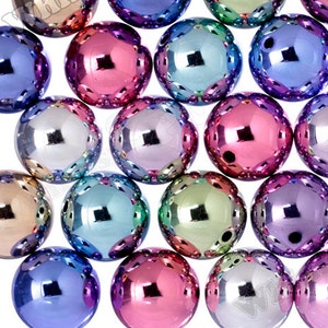 May include: A collection of iridescent round beads with a scalloped edge. The beads are various shades of pink, purple, blue, and green.